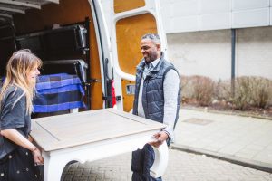 Witte tafel die in bezorgbus gezet word. 