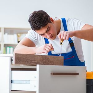 Een man die meubels repareert.